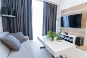 sala de estar con sofá blanco y TV en Apartman Amore, en Baška Voda