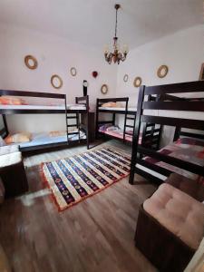 a room with three bunk beds and a rug at Hostel Musala in Mostar