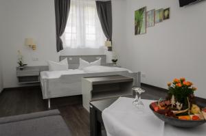 una habitación con 2 camas y una mesa con un bol de fruta en Hotel Rheingraf en Kamp-Bornhofen