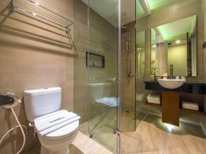 a bathroom with a toilet and a shower and a sink at Puri Asri Hotel & Resort in Magelang