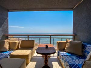 a room with couches and a table and a large window at Уютный дом на первой линии моря in Chornomorsk