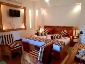 um quarto com uma cama, uma cadeira e uma televisão em Leisure Dream Inn em Ella
