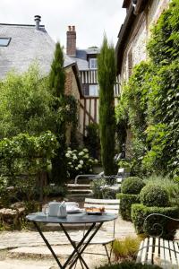 uma mesa com um prato de comida no jardim em La Cour Sainte Catherine demeure de charme em Honfleur