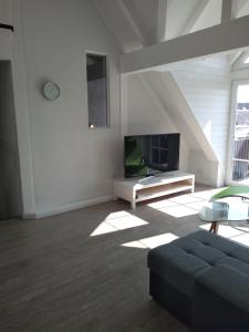 - un salon avec un canapé et une télévision dans l'établissement Willkommen in unserem kleinen Paradies, à Venningen