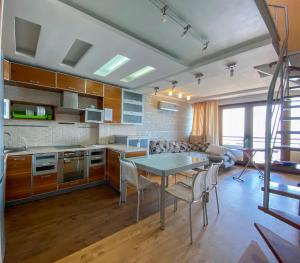 a kitchen with a table and a dining room at Уютный дом на первой линии моря in Chornomorsk