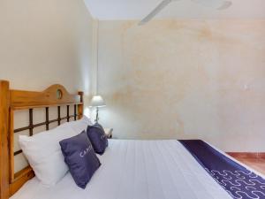 a bedroom with a bed with blue and white pillows at Hotel Valle De Oaxaca in Oaxaca City