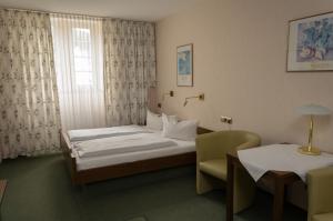 ein Hotelzimmer mit einem Bett, einem Tisch und Stühlen in der Unterkunft Hotel Rheingraf in Kamp-Bornhofen