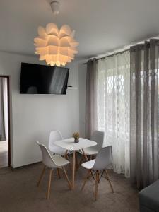 a dining room with a table and chairs and a chandelier at Apartament u Gogoca II in Tylicz