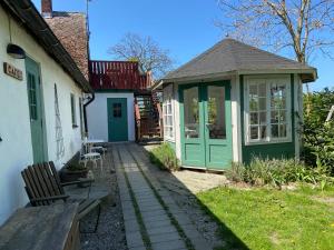 una casa con una puerta verde y un banco en Kungshagagård, en Höllviken