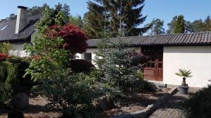 een huis met bomen en bloemen ervoor bij Ferienhaus am Mühlenweg in Winsen