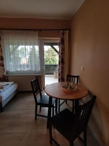 a room with a table and chairs and a bedroom at W Starym Ogrodnictwie in Przyszowice