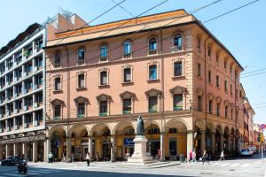 a large brick building with a statue in front of it at UR-NEST Battisti in Bologna
