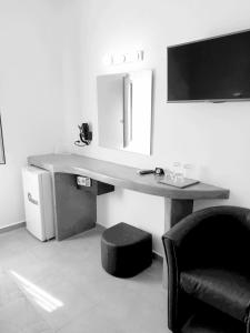 a desk with a chair and a computer in a room at Hotel Leta in Fira