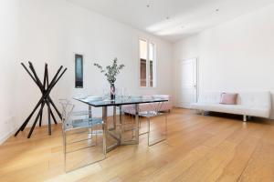 ein Wohnzimmer mit einem Tisch, Stühlen und einem Sofa in der Unterkunft UR-NEST Battisti in Bologna