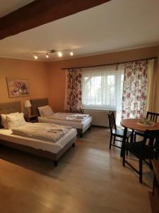 a bedroom with two beds and a table and a window at W Starym Ogrodnictwie in Przyszowice