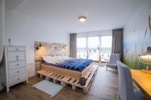 a bedroom with a large bed and a desk at Apart Harmony - Apartamenty Zatoka Pucka in Puck