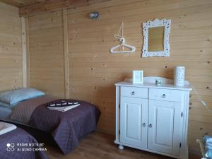 um quarto com uma cama e um espelho na parede em Wróblówka- domek na wsi em Parczew