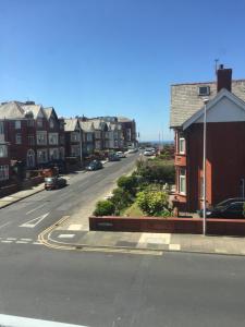 a city street with houses and cars on the road w obiekcie The Fernroyd w Blackpool