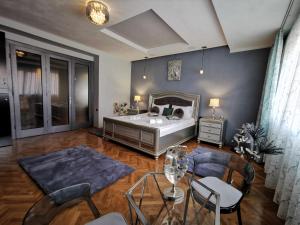 Schlafzimmer mit einem Bett, einem Tisch und Stühlen in der Unterkunft Crystal Central Apartment in Braşov