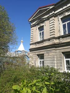 een gebouw met ramen en een wit dak bij Golden Amber Apartment in Liepāja