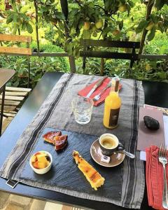 a picnic table with a plate of food and a bottle of wine at La Cour Sainte Catherine demeure de charme in Honfleur