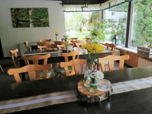 una sala da pranzo con tavoli, sedie e fiori su un tavolo di Storchennest Spreewald a Vetschau