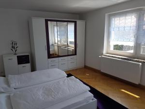 a white room with two beds and two windows at Pferdehof Jäger in Markranstädt