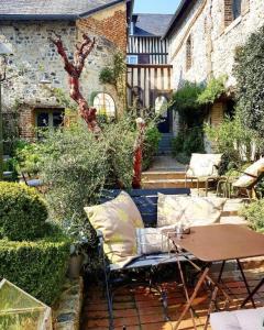a patio with a table and a table and chairs at La Cour Sainte Catherine demeure de charme in Honfleur