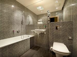 a bathroom with a toilet, sink, and bathtub at EA Hotel Crystal Palace in Prague