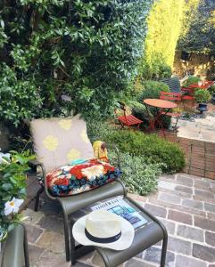 a chair with a pillow sitting next to a table at La Cour Sainte Catherine demeure de charme in Honfleur