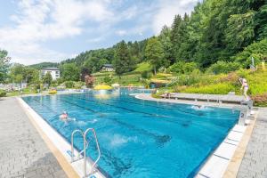 a large swimming pool with people in the water at Ferienhaus Sonnrain in Leogang