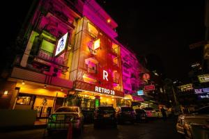 a building with neon lights on a city street at Retro39 in Bangkok