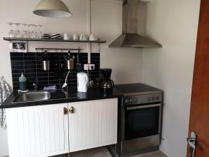 a kitchen with a sink and a stove at Grand-Inn Bar and Bed in Sauðárkrókur