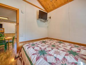 a bedroom with a bed with a quilt on it at Maggie Valley Cabin Rentals in Maggie Valley