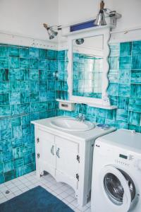 uma casa de banho em azulejos azuis com uma máquina de lavar roupa em Gemütliches Wohnen in der alten Schule em Weitra