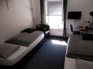 um pequeno quarto com 2 camas e uma janela em Bed & Breakfast Zuidlaren em Zuidlaren