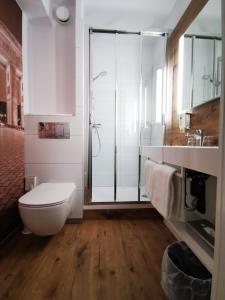 a bathroom with a toilet and a glass shower at Plaza Inn Berlin Süd Ludwigsfelde in Ludwigsfelde