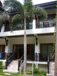 a building with palm trees in front of it at Marina Villa in Lamai