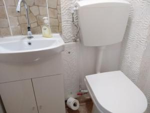y baño con aseo blanco y lavamanos. en Comfortable Home Ermoupolis en Ermúpoli