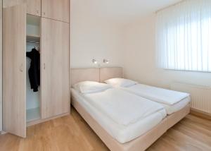 クックスハーフェンにあるHaus Seemuschel _ Fewo 2の白いベッドルーム(ベッド1台、クローゼット付)