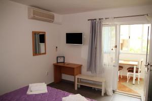 a bedroom with a bed and a desk and a window at Apartments Milena & Ante in Makarska