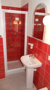 a red bathroom with a sink and a shower at Nicola's Apartments in Marina di Campo