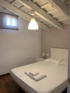 バレンシアにあるUp Townのベッドルーム1室(白いベッド1台、タオル2枚付)