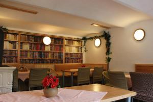 a restaurant with tables and chairs and shelves of books at Penzion Pohádka in Železná Ruda