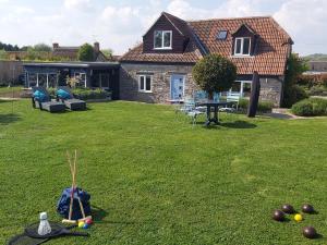 een tuin met een huis en wat ballen op het gras bij Bluebell House 5 Star Holiday Let in Somerton