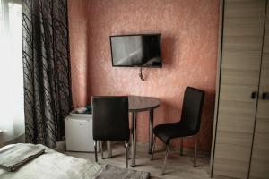 a room with a table and two chairs and a tv on the wall at MARMAT Łeba in Łeba