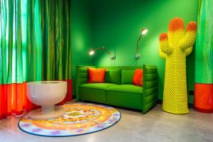 a green living room with a couch and a cactus at Laurichhof in Pirna