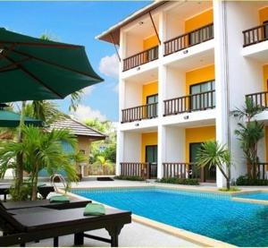 a hotel with a swimming pool in front of a building at Krabi Cozy Place in Krabi