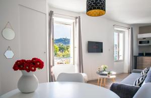 Totolulu Cannes Smart في كان: غرفة معيشة مع طاولة بيضاء و إناء من الزهور