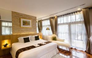 a bedroom with a large bed and a large window at Sireeampan Boutique Resort and Spa in Chiang Mai
